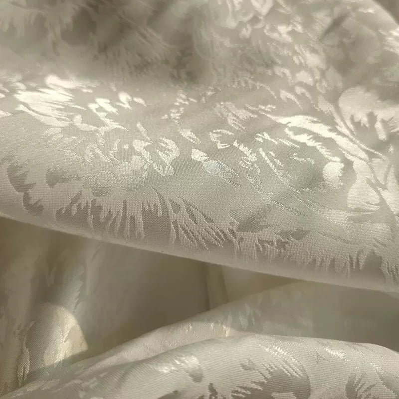 Tejido satinado jacquard floral en tono blanco marfil ‑sobre‑tono